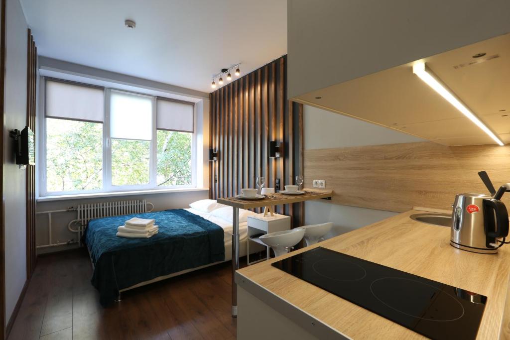 a bedroom with a bed and a kitchen with a sink at BROADWAY apartments in Moscow