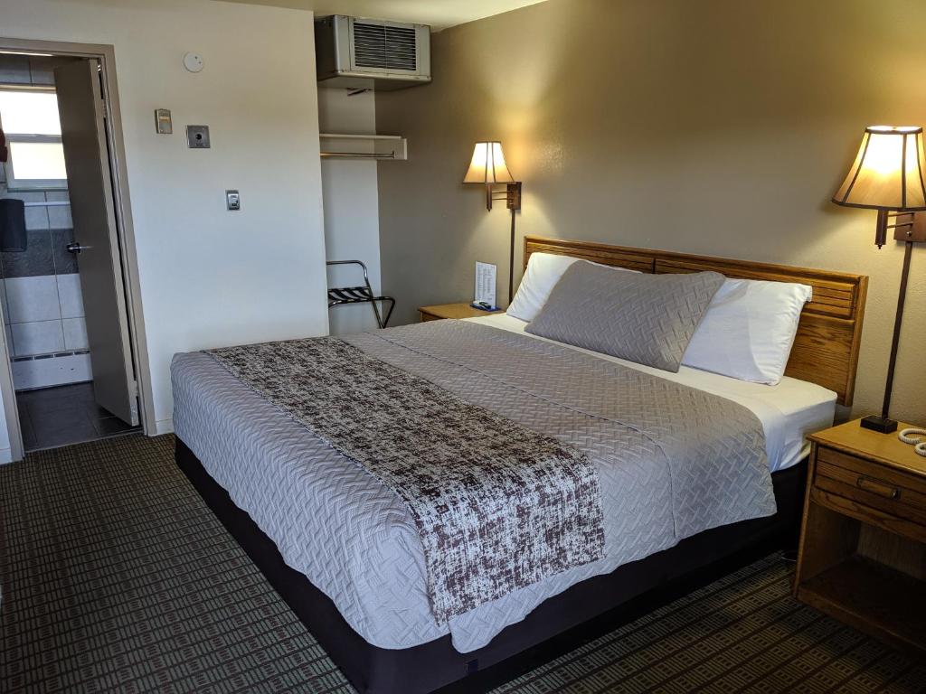 a hotel room with a bed and two lamps at Economy Inn Elko in Elko