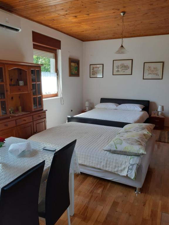 two beds in a room with a table and two beds at Apartment NATUR in Zagreb