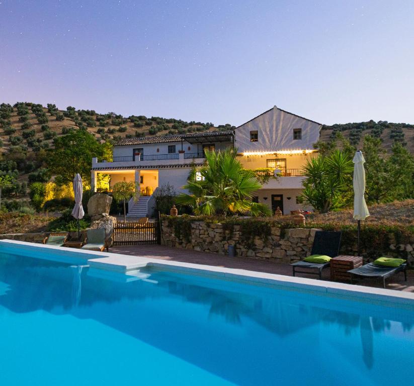 a swimming pool in front of a house at Caseria De San José in Iznájar