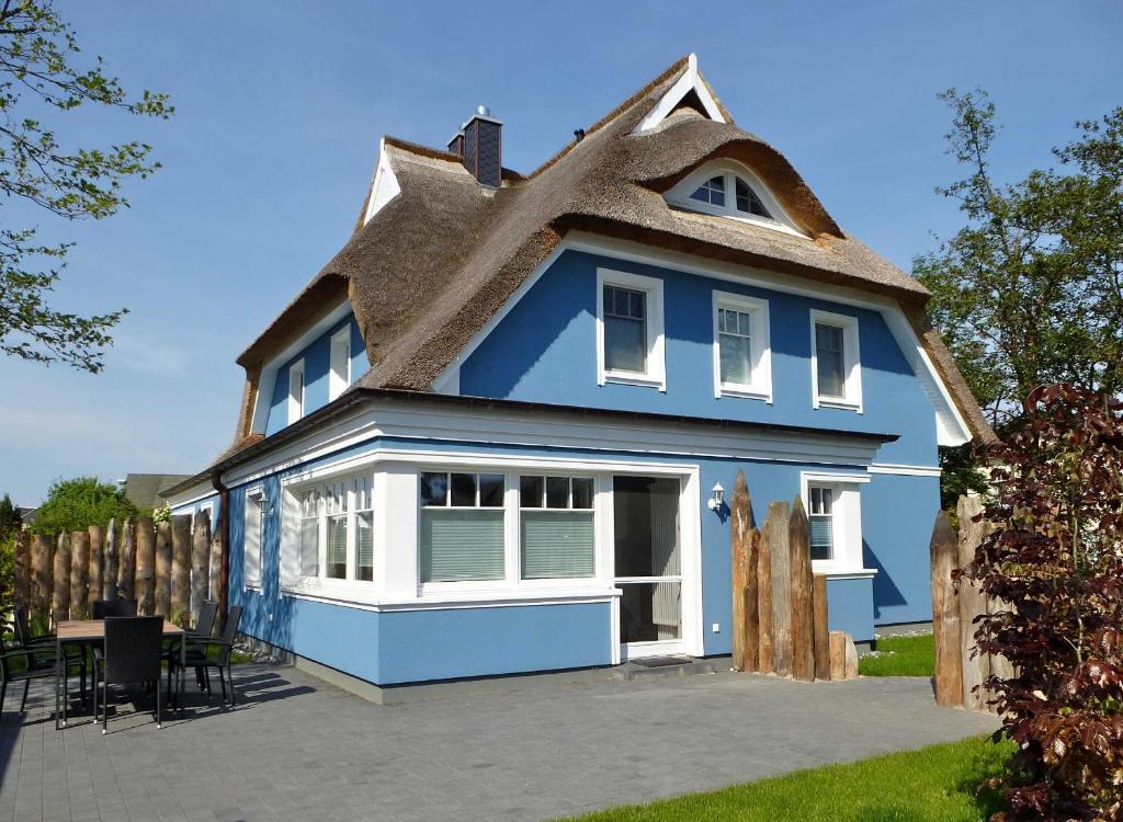 a blue house with a thatched roof at Friedenstrasse Haus Kranich in Zingst