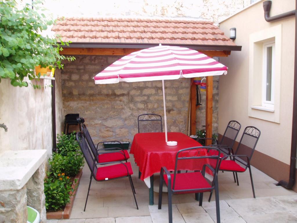 een tafel en stoelen met een parasol op een patio bij Mirina in Stari Grad