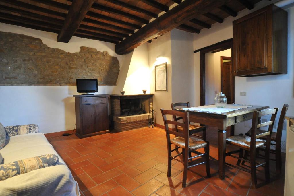 een slaapkamer met een bed, een tafel en een open haard bij La Casa nel Castello di Gaiche in Piegaro