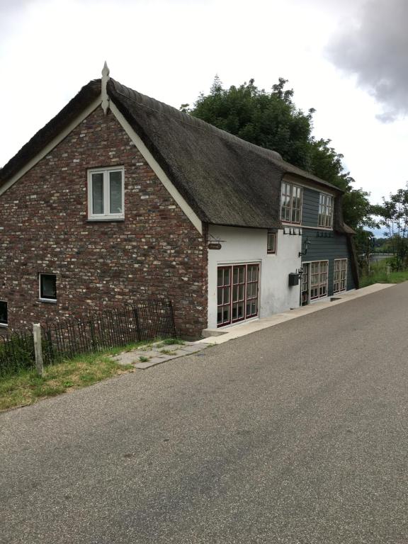 een oud bakstenen gebouw aan de kant van een weg bij Bij ons op Vogelswerf in Heukelum