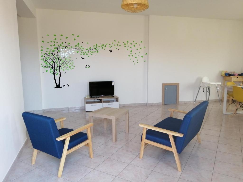ein Wohnzimmer mit Stühlen, einem Tisch und einem TV in der Unterkunft B&B Ginevra in Gizzeria