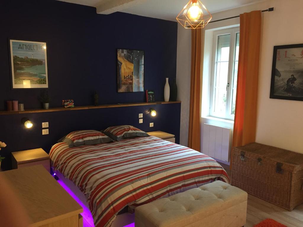 a bedroom with a bed with purple lights on it at L appartement du parc in Villemur-sur-Tarn