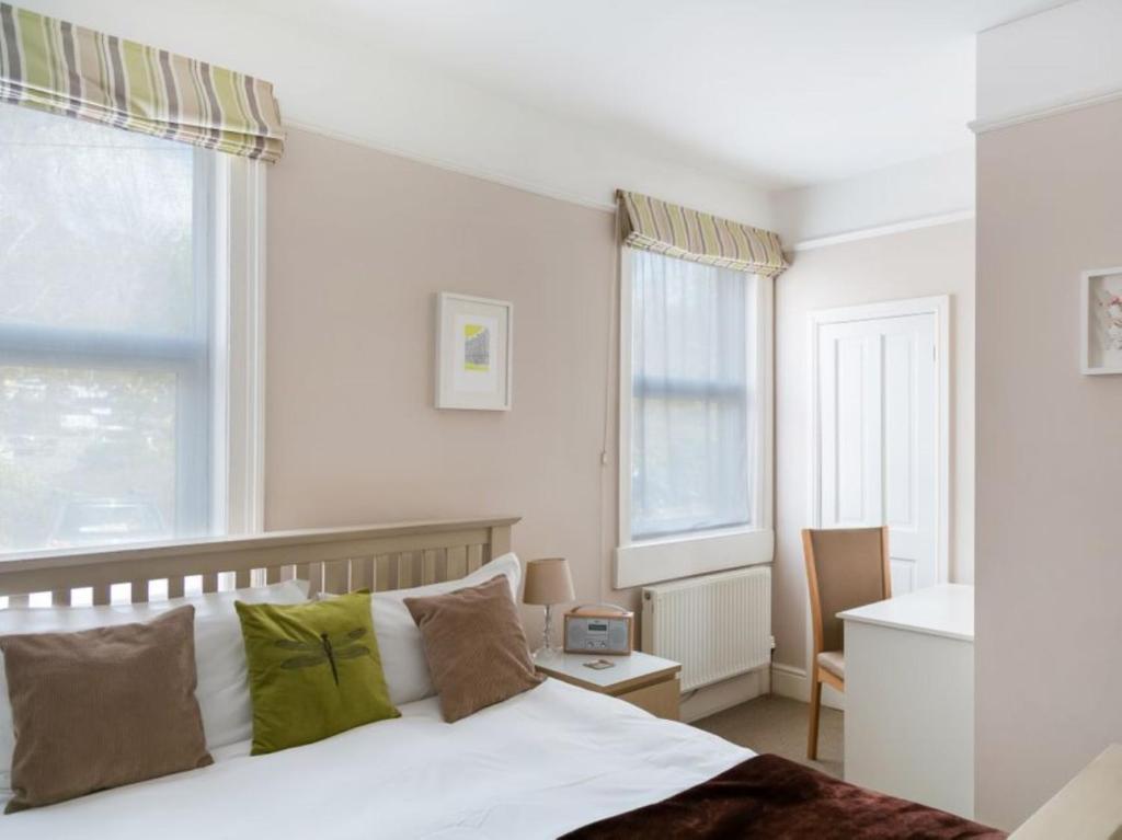 1 dormitorio con cama blanca y almohadas verdes en Bay Tree House en Bath
