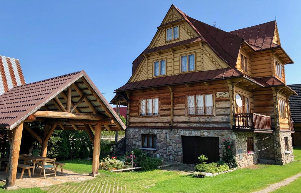 uma grande casa de madeira com um telhado de gambrel em Apartamenty u Krysi em Witów