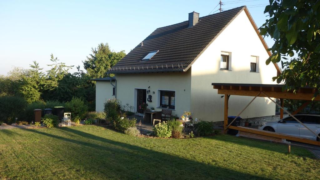 ein weißes Haus mit einem Dach auf einem Hof in der Unterkunft Ferienwohnung Tine in Oberhausen