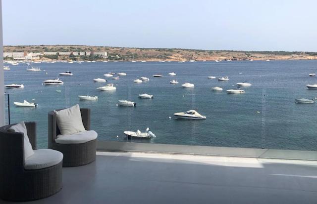 a room with a view of a body of water with boats at Mellieha Bay Waters Edge No. 160 in Mellieħa