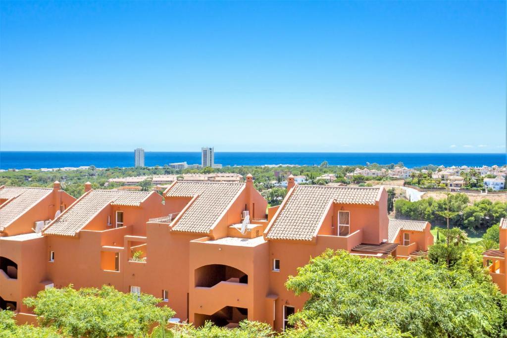 una fila de casas naranjas con el océano en el fondo en REF 1 Spacious Sea View Apartment, en Marbella