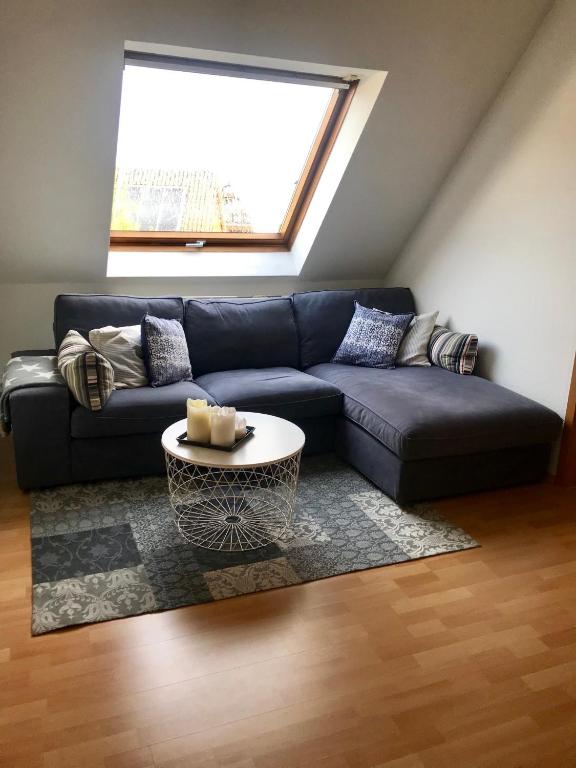 a living room with a blue couch and a table at Rheinau Apartment in Memprechtshofen