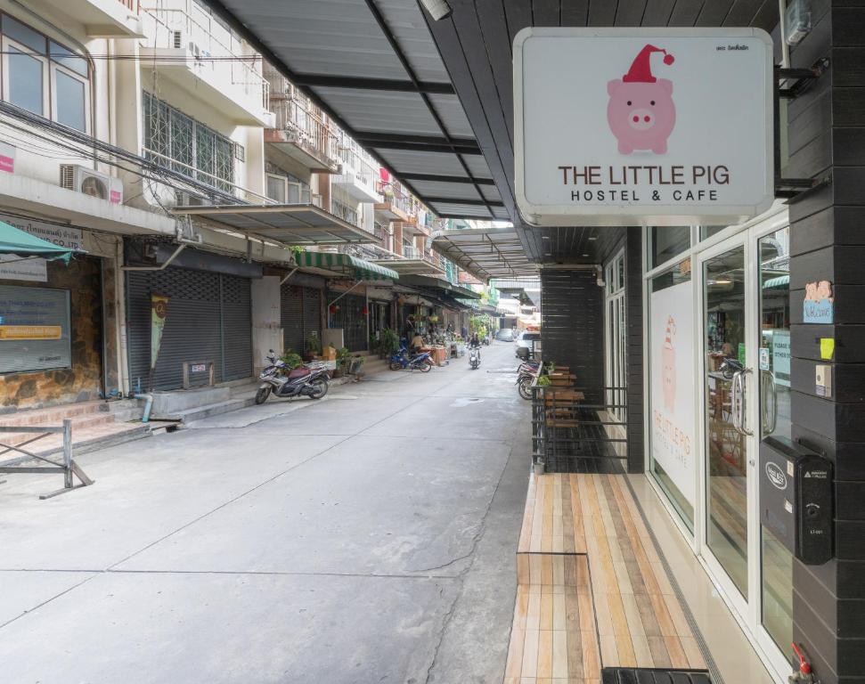an empty street with a sign for the little pig market and cafe at The Little Pig Sukhumvit in Bangkok