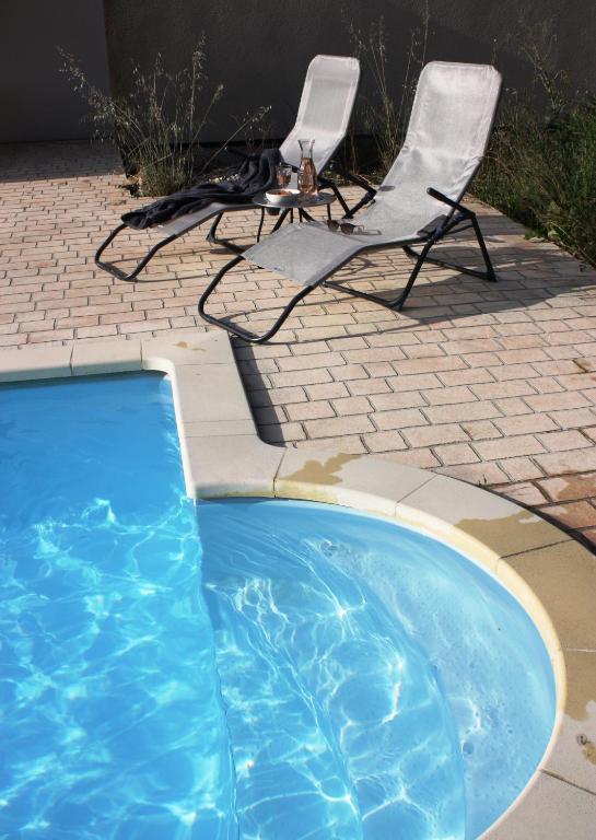 une chaise, une chaise et une chaise, ainsi qu'une piscine dans l'établissement Chez Marius, à Lagorce
