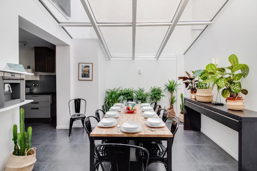 a long table in a room with plants at NOCNOC - Villa Paradis, piscine et rooftop au coeur de Nantes in Nantes