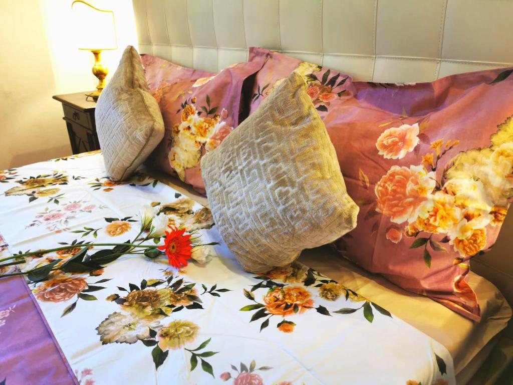 un letto con cuscini sopra di Borgo Ognissanti Central and Charming Location a Firenze
