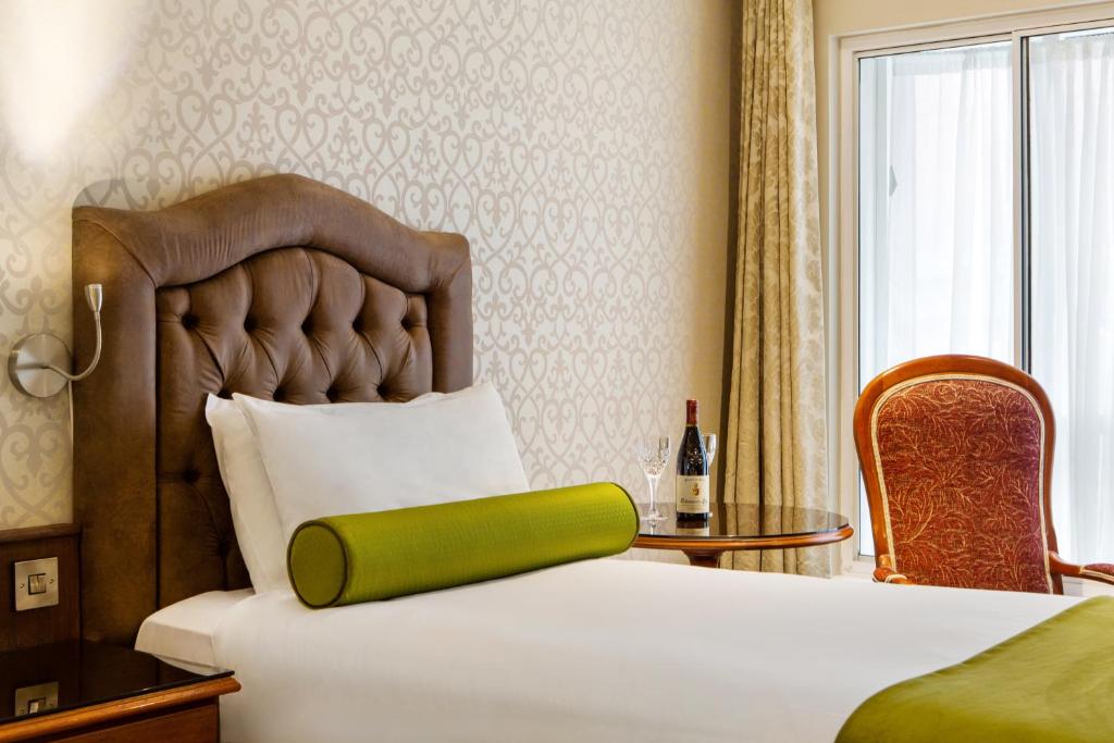 a hotel room with a bed with a green pillow on it at Drury Court Hotel in Dublin