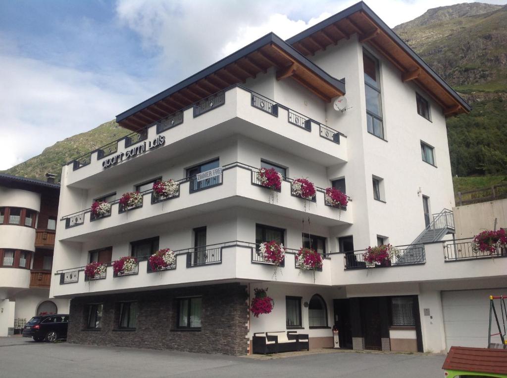 a large white building with flowers on the balconies at Apart Garni Lais in Galtür