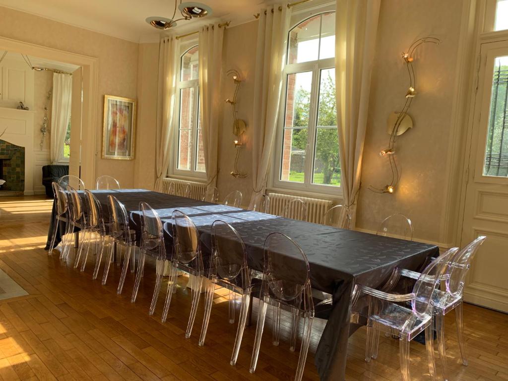 uma sala de jantar com uma mesa preta e cadeiras em Gîte de Lafleur em Dury