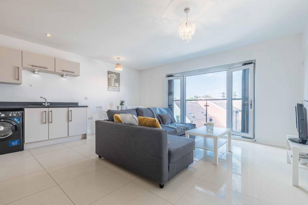 a living room with a couch and a kitchen at The Penthouse @ Waterside Grange in Slough