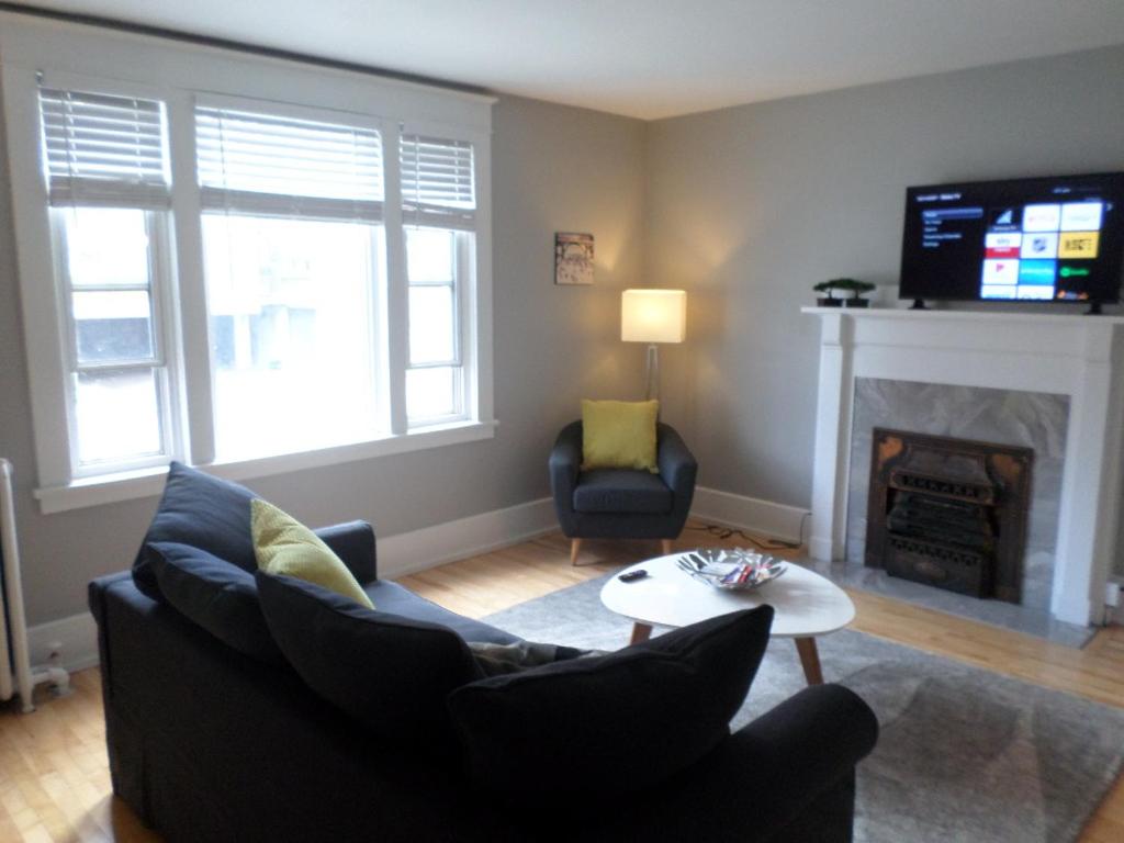 a living room with a couch and a fireplace at Beautiful, Clean, Quiet 2 BR-In Downtown Ottawa. Parking, WIFI and Netflix Included in Ottawa