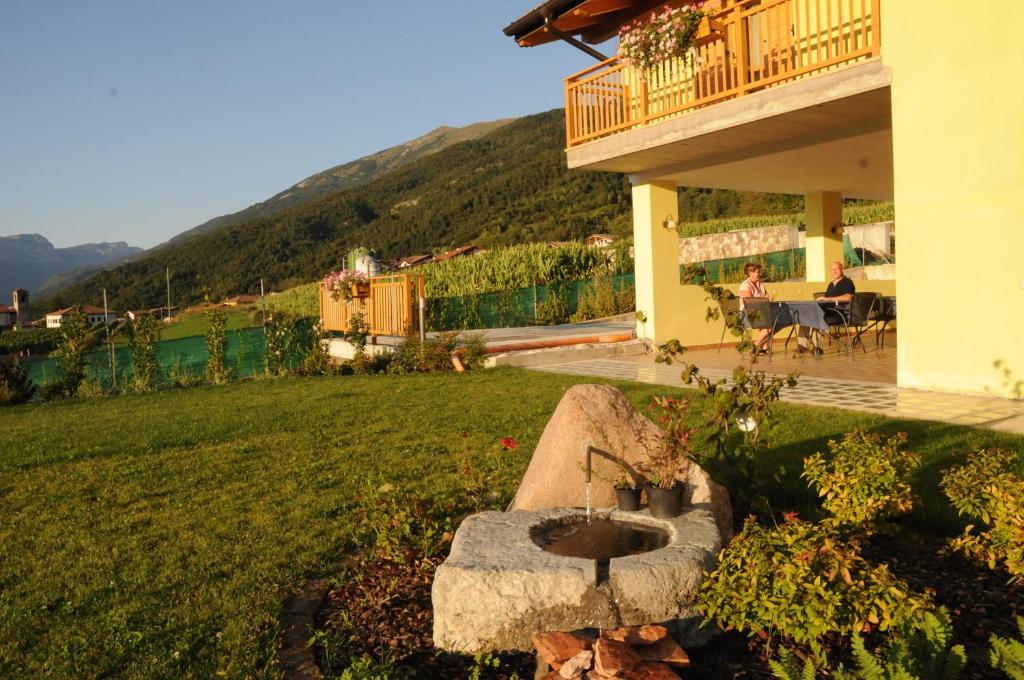 una casa con un baño de aves en un patio en Agritur Campo Fiorito, en Dro