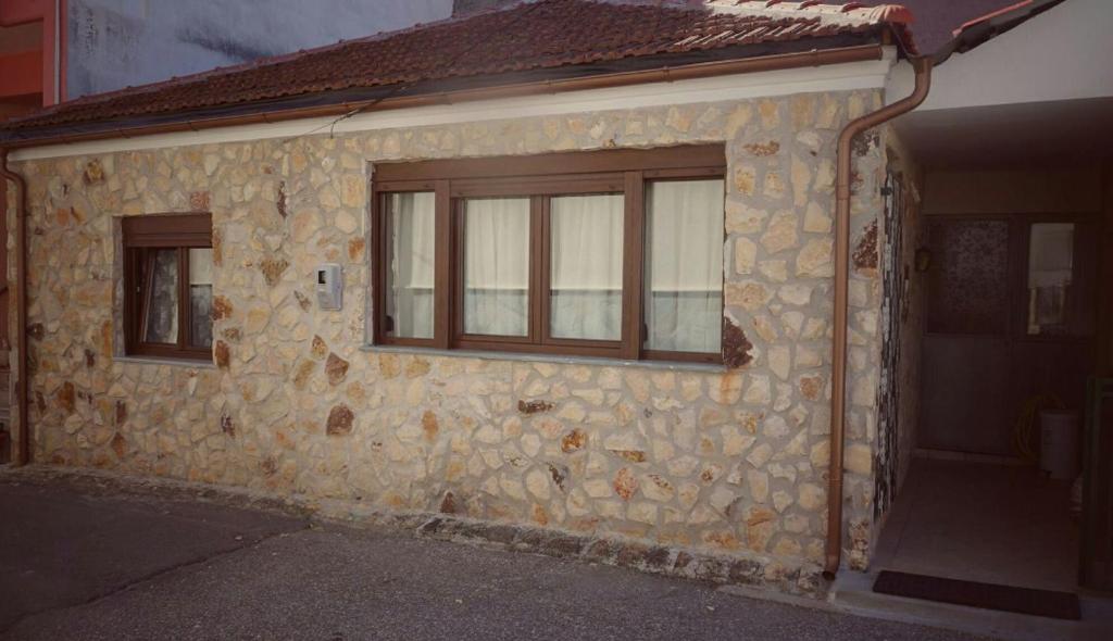 um edifício de pedra com uma janela e uma porta em Village House Grevena em Grevena