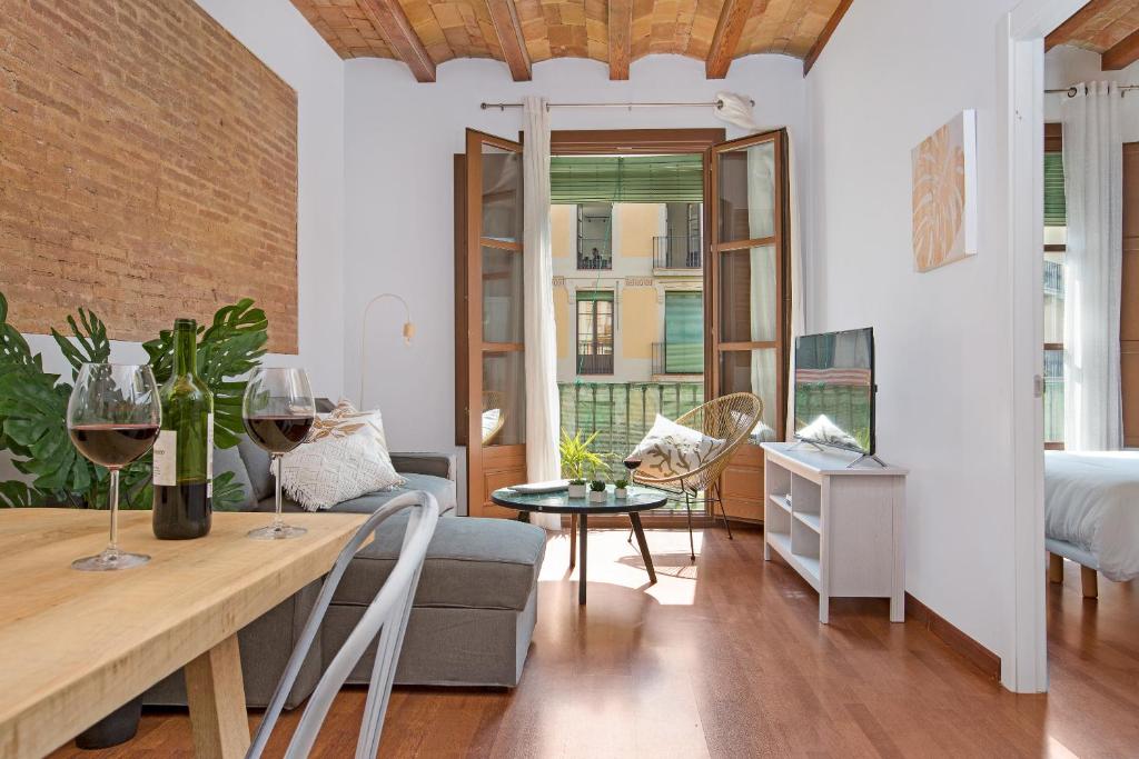 ein Wohnzimmer mit einem Sofa und einem Tisch mit Weingläsern in der Unterkunft Stay U-nique Apartments Girona in Barcelona