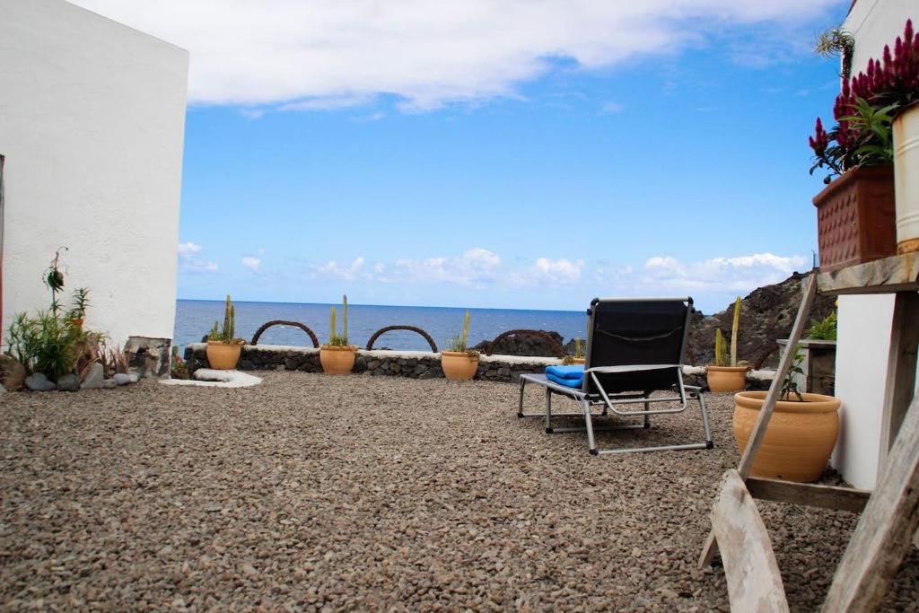 a patio with chairs and the ocean in the background at Pura Vida Casa del Mar in Breña Baja