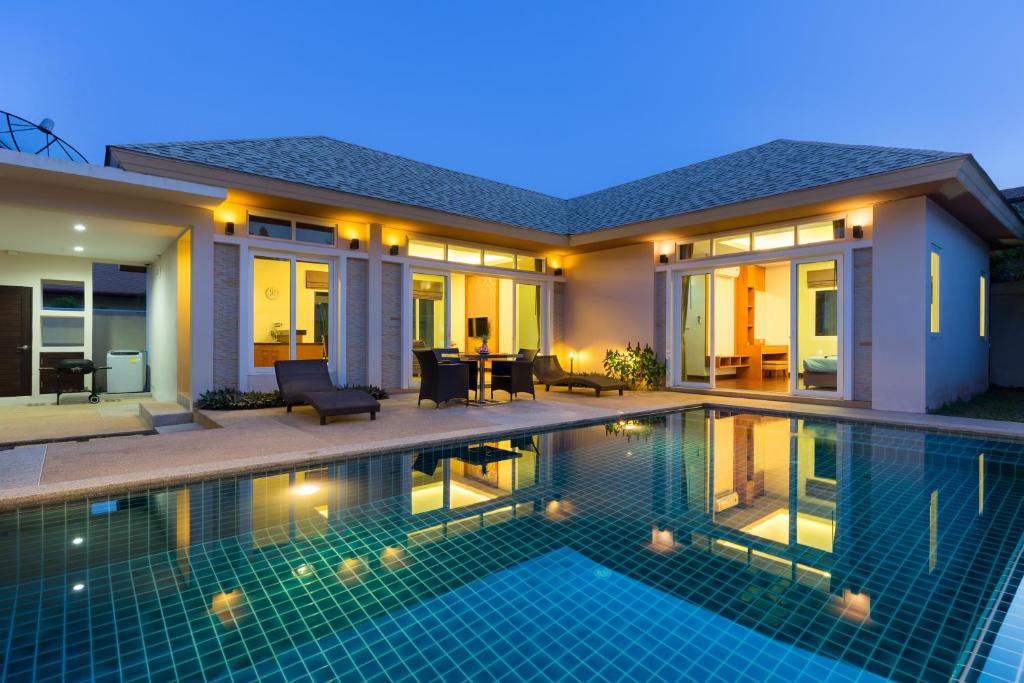 a villa with a swimming pool at night at Villa Jasmine in Rawai Beach