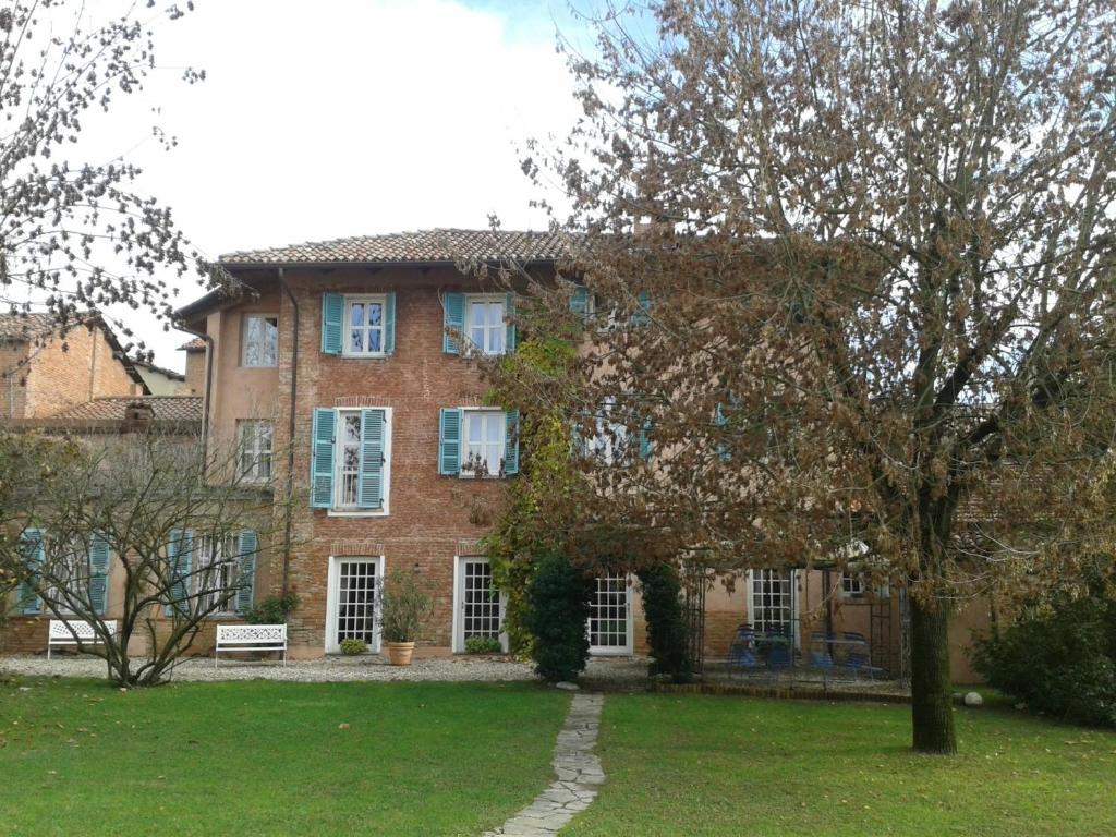 una gran casa de ladrillo con un árbol delante en Villa Belforte, en Tonco