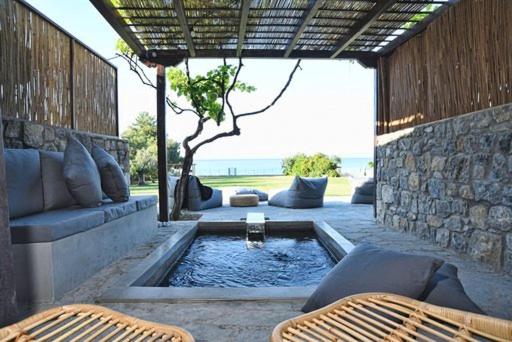 a patio with a pool with two chairs and a table at Γεράνι Suite in Ktima Gerostathi in Polykhrono
