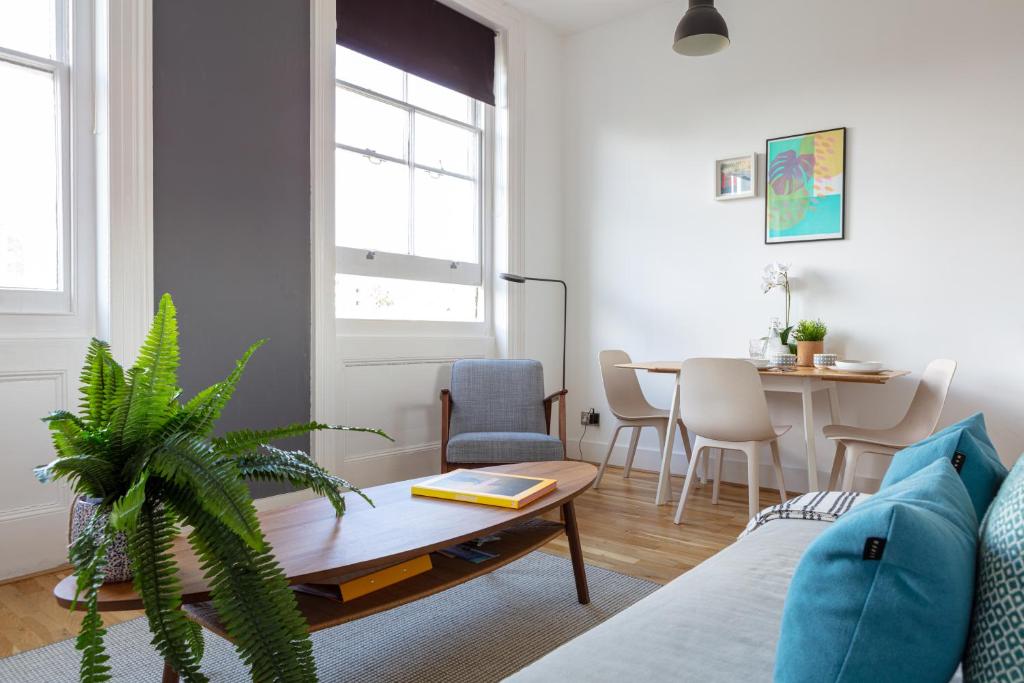 a living room with a couch and a table at Stylish Central Brighton Apartment 500 m from Brighton Beach in Brighton & Hove