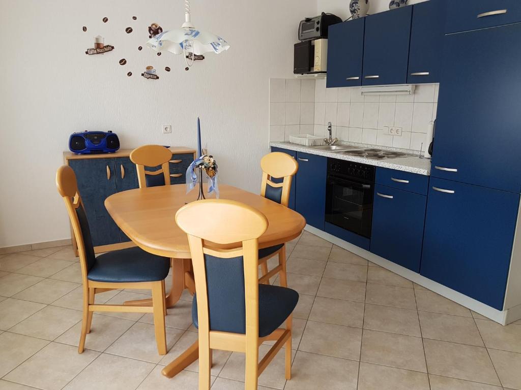 a kitchen with a wooden table and blue cabinets at Ferienwohnung keine Monteurvermietung Nähe Heidelberg Hockenheim BDS Anlage in Philippsburg