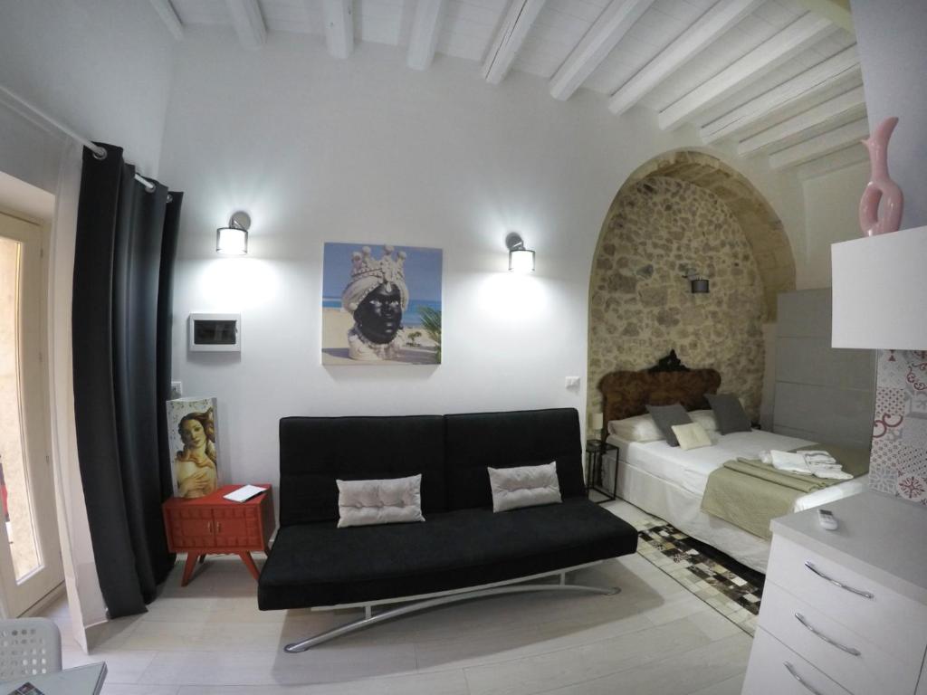 um quarto com uma cama e um sofá num quarto em Ammira em Siracusa