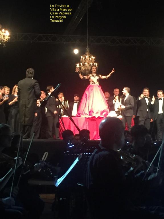 kobieta w sukience na scenie z tłumem w obiekcie Casa Vacanza La Pergola w mieście Terrasini