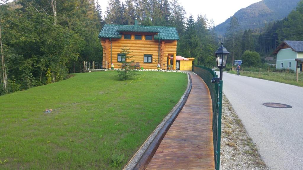 una pasarela de madera que conduce a una cabaña de madera en Ferienwohnungen Blockhaus - Zwergenhäusl Grünau im Almtal, en Grünau im Almtal