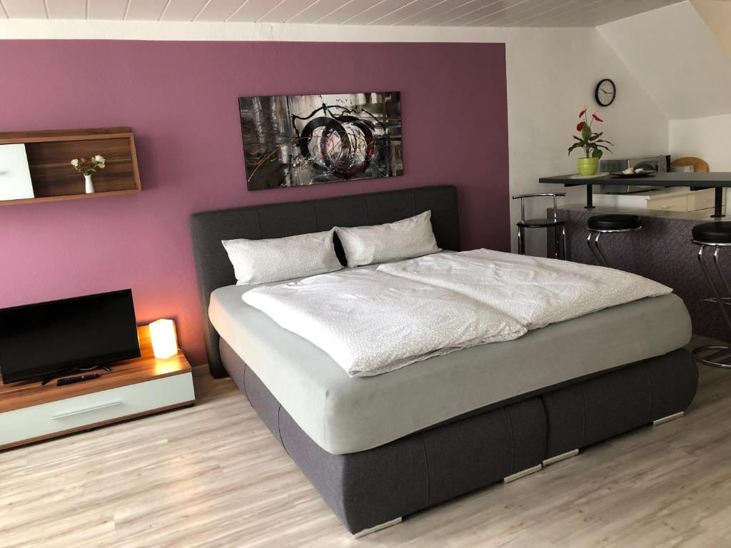 a bedroom with a bed and a purple wall at Haus Linde Frauenwald am Rennsteig in Frauenwald