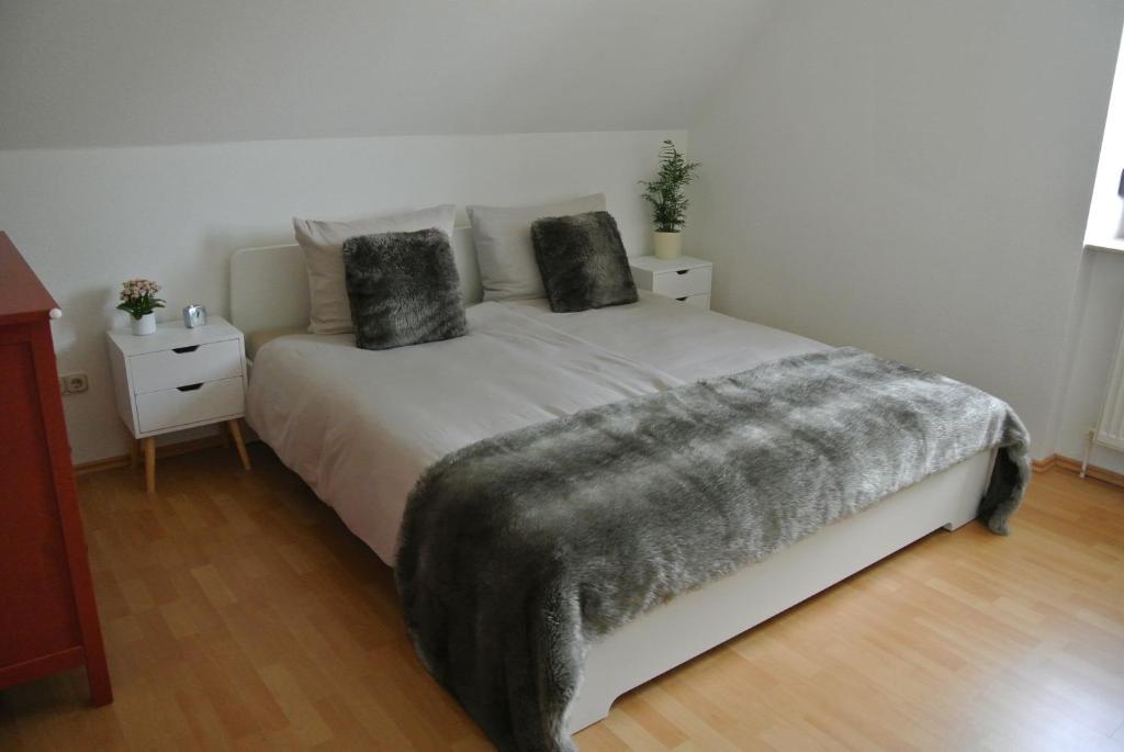 a bedroom with a bed with a gray blanket on it at Rheinau Apartment in Memprechtshofen