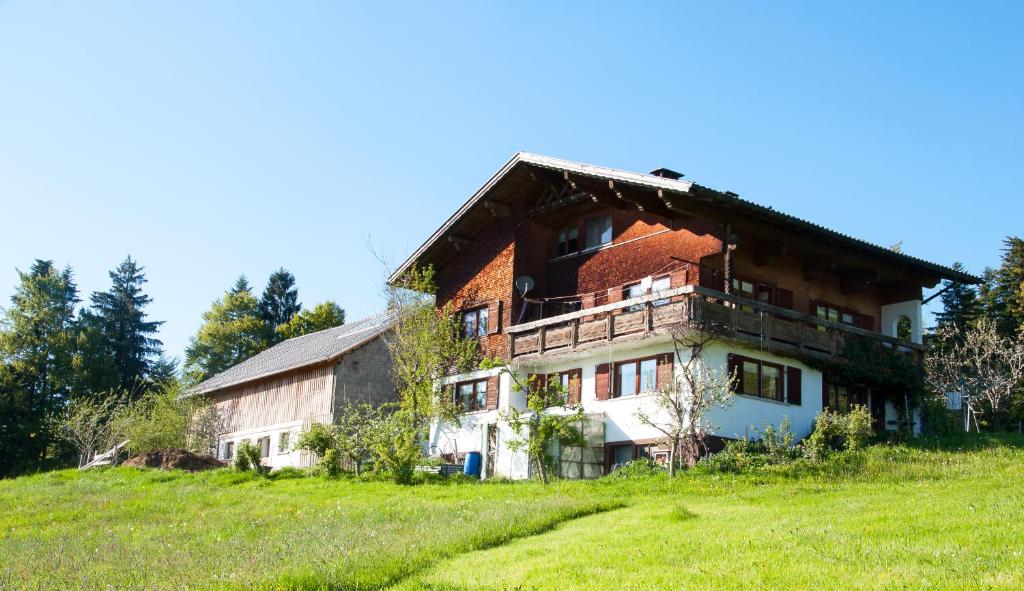 stary dom na szczycie trawiastego wzgórza w obiekcie Ferien in Feld 109 w mieście Langenegg