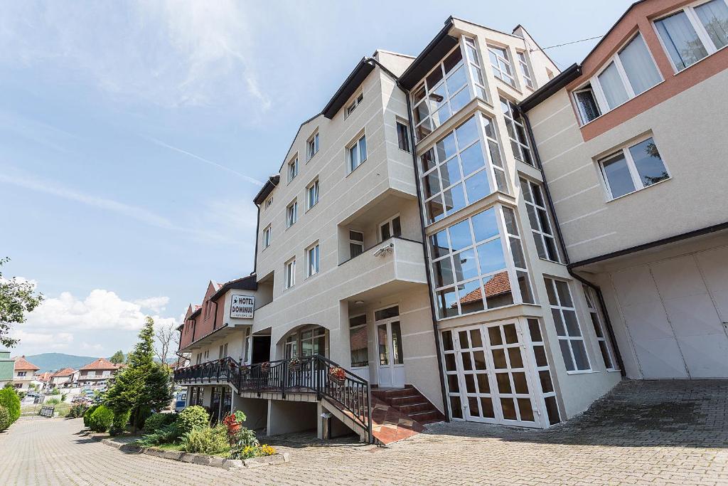 an apartment building with a staircase on the side of it at Hotel Dominus in Bijelo Polje