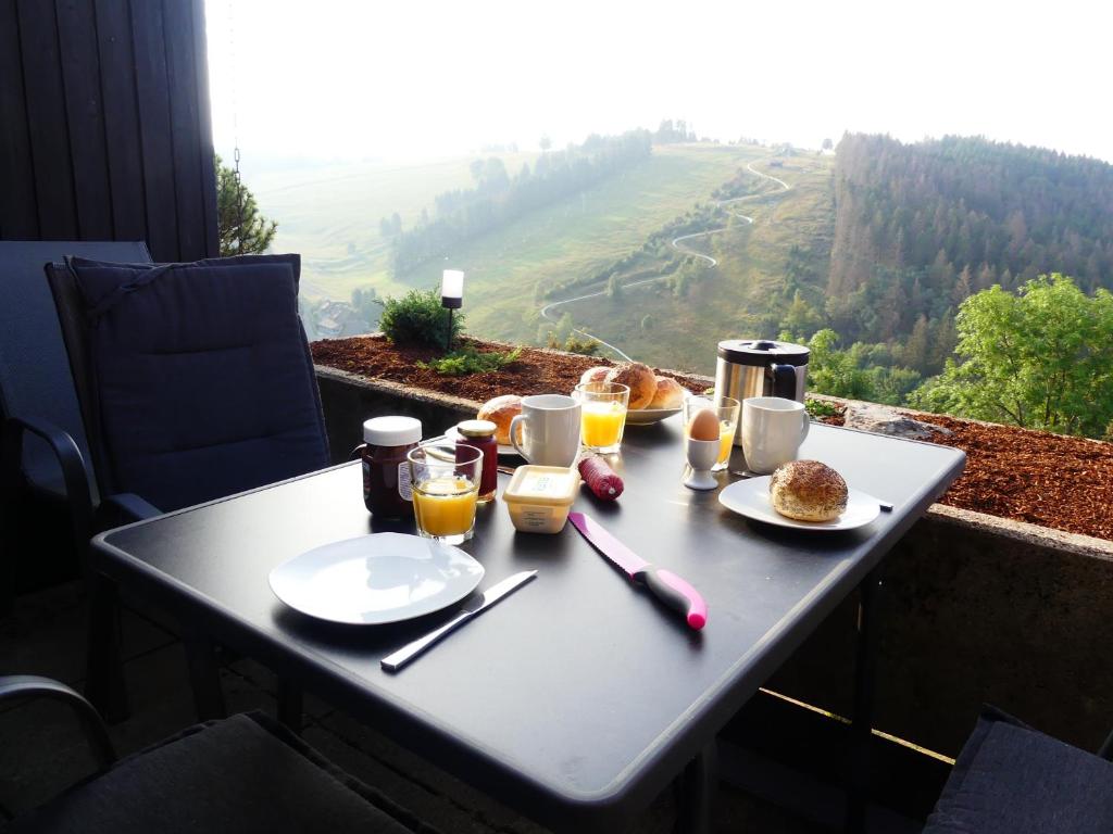 a table with food and drinks on top of a mountain at Traumblick in Sankt Andreasberg
