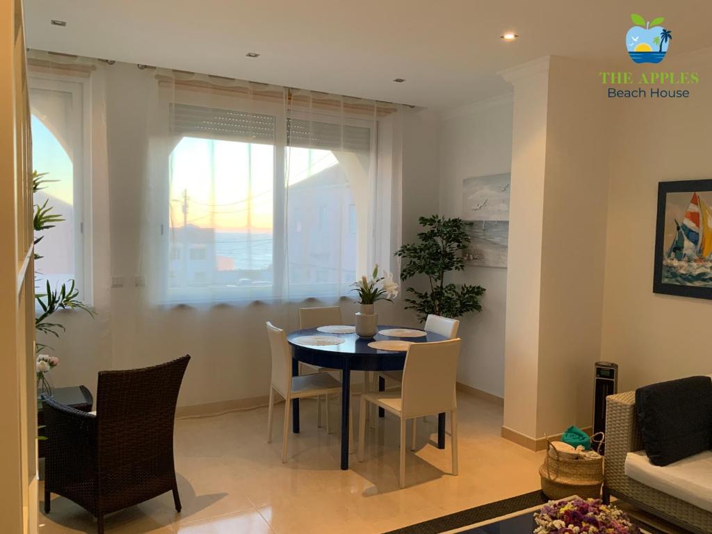 a dining room and living room with a table and chairs at The Apples - Beach House in Sintra