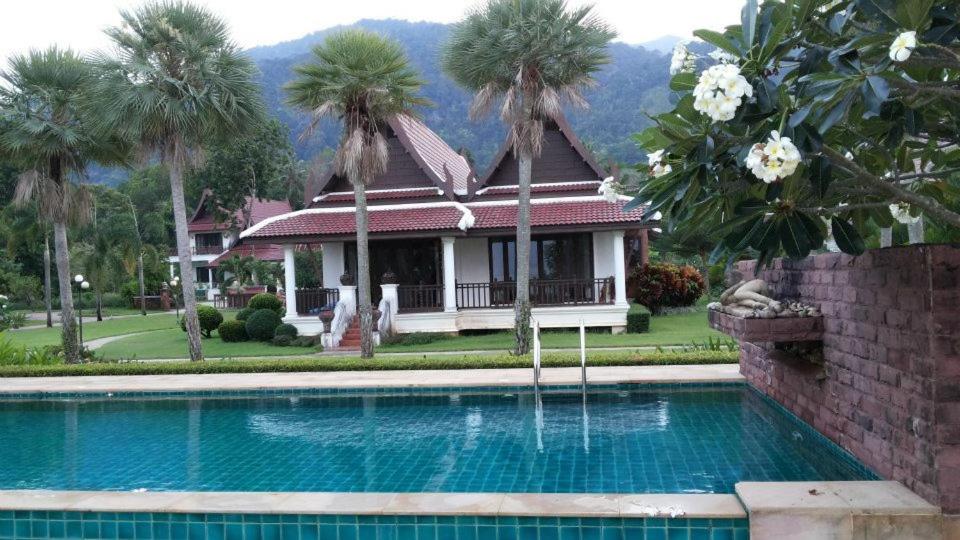 a house with a swimming pool in front of a house at Gardenia Oceanfront Villa in Ko Chang