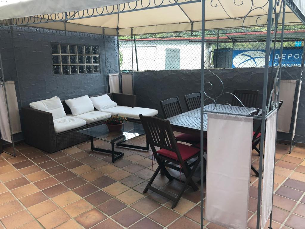 un soggiorno con divano e tavolo di Apartamento con terraza y chimenea a La Rebollada