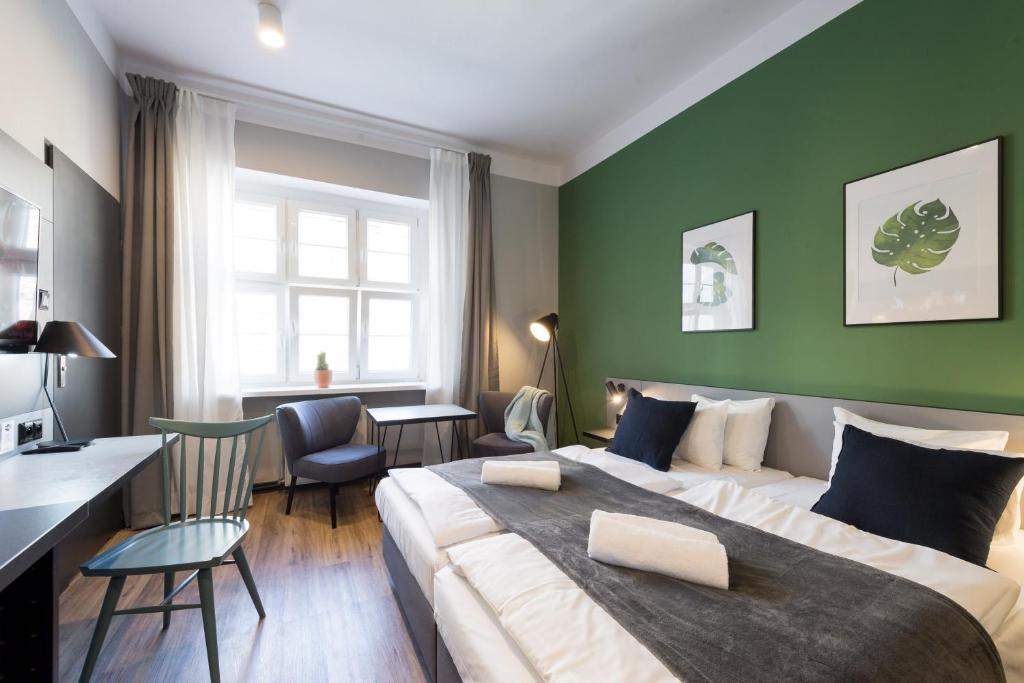 a bedroom with a large bed and a green wall at Stary Rynek Old Market Apartments in Poznań