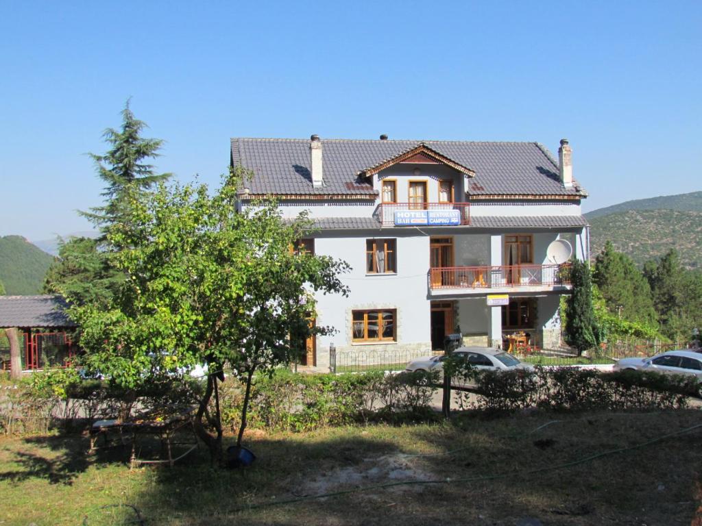 a large white house with a tree in front of it at Hotel Germenji in Gërmenj