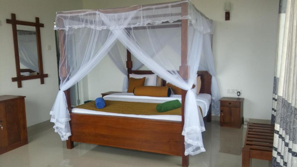 a bedroom with a bed with a canopy at Senasuma Homestay in Ella