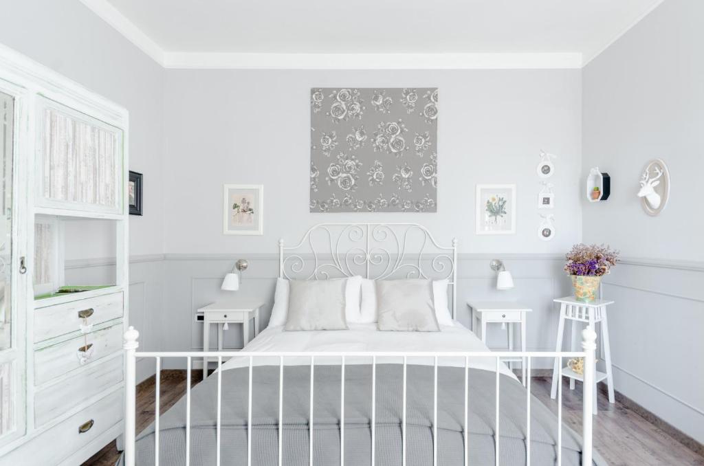 Dormitorio blanco con cama blanca y armarios blancos en Il Cottage, en Vigevano