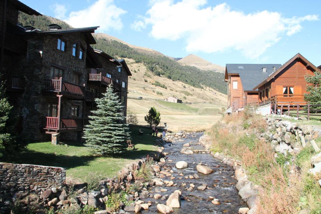 um rio em frente a um edifício e a uma casa em ESTANYOL - Peu del Riu 401 - Vall d'Incles - Soldeu em Incles